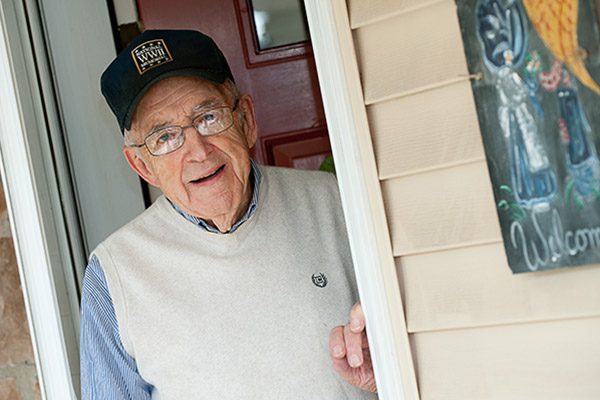 An older gentlemen standing in the doorway.